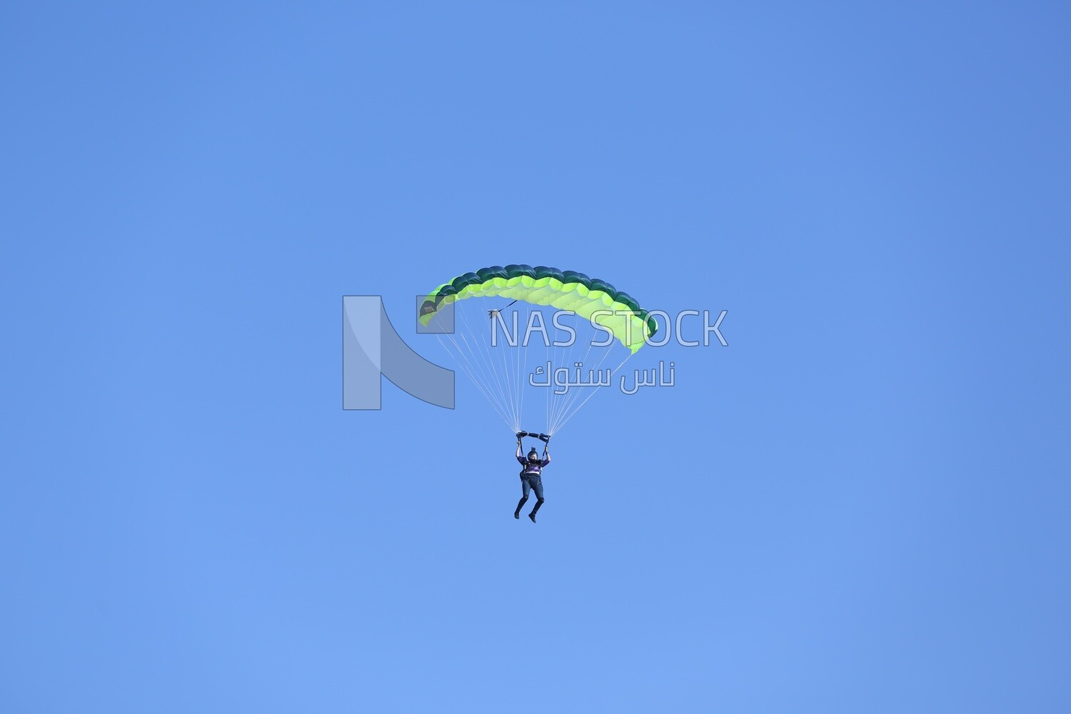 A person flying in the sky wearing a parachute