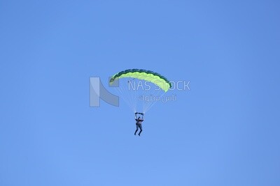 A person flying in the sky wearing a parachute