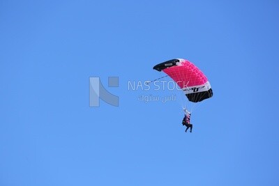 Girl flying in the sky wearing a parachute