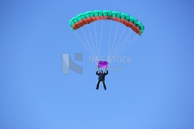 A person flying in the sky wearing a parachute