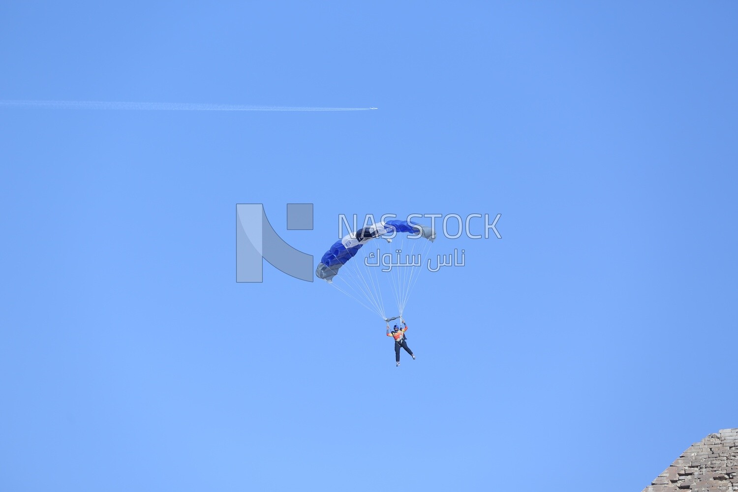 A person flying in the sky wearing a parachute