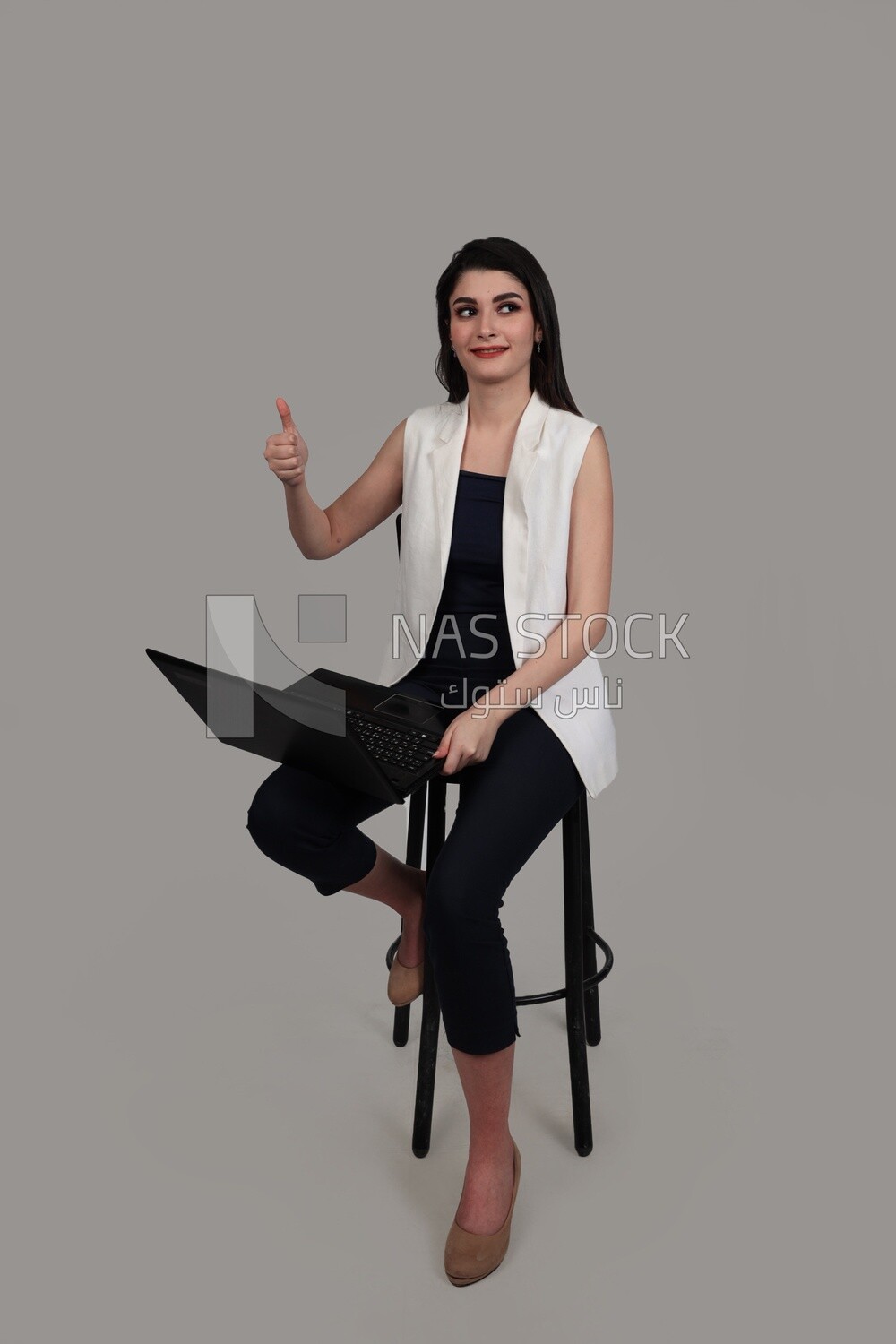 Photo of a businesswoman with formal wear sitting on a chair working on a laptop, business development and partnerships, business meeting, Model
