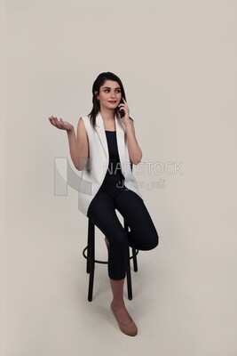 Photo of a businesswoman with formal wear sitting on a chair talking on the phone, business development and partnerships, business meeting, Model