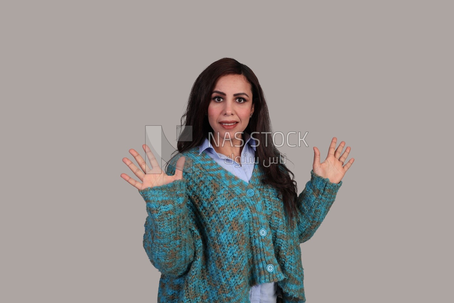 beautiful woman with long brown hair and winter clothes standing surprised