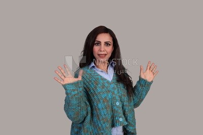 beautiful woman with long brown hair and winter clothes standing surprised