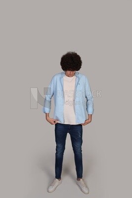 young man with curly hair arranging his clothes