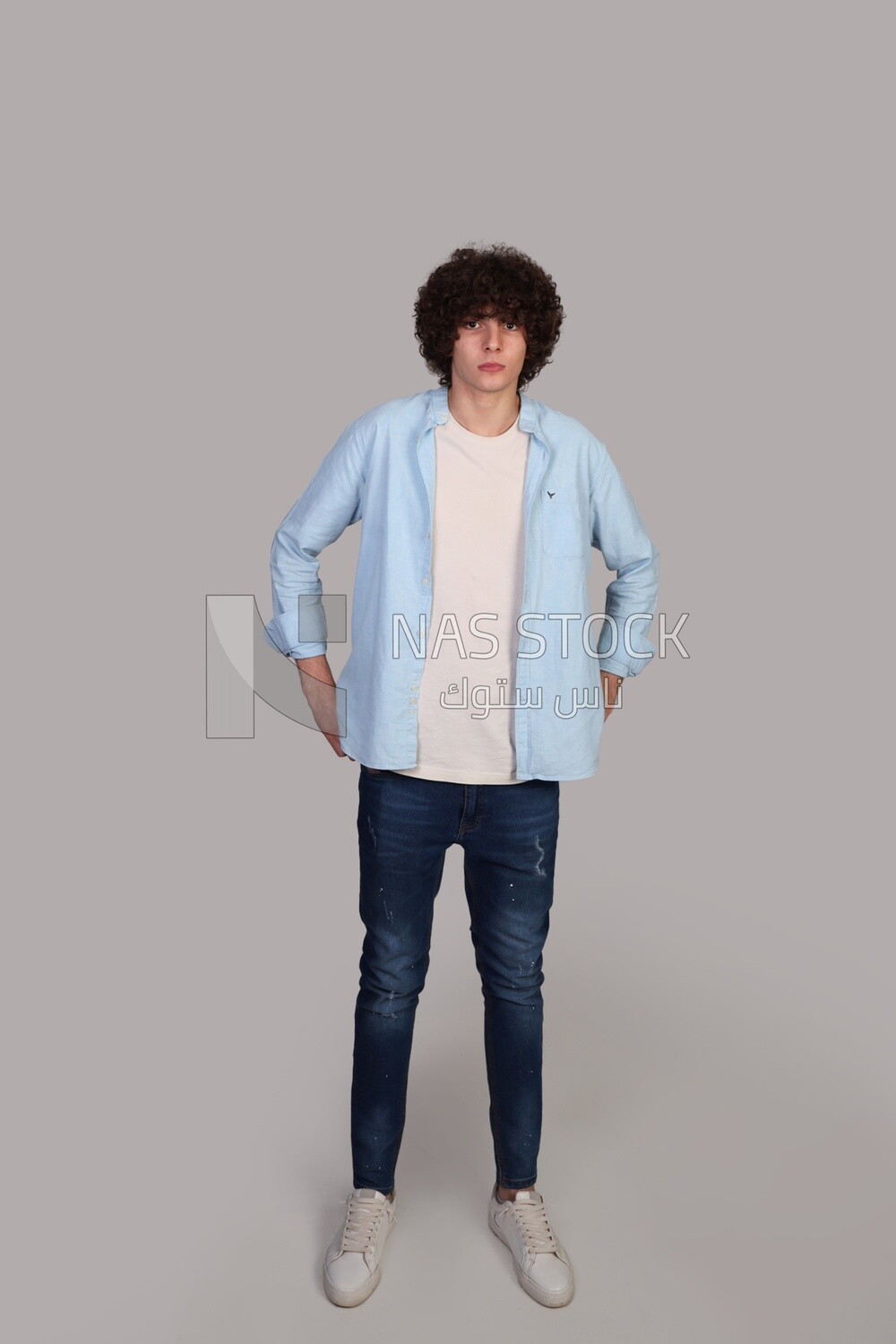 handsome young man with thick curly hair standing