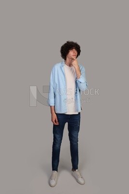 young man with curly hair looking up and thinking