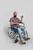 man sitting in a wheelchair holding a credit card, patient, the concept of medicine and health care, an appointment to receive treatment in the hospital, emergency.