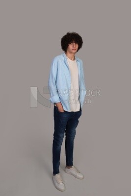 young man with curly hair, wearing a shirt and putting his hand in his pocket