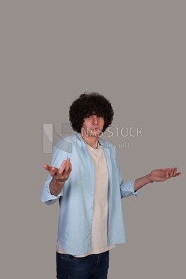 young man with curly hair standing amazed