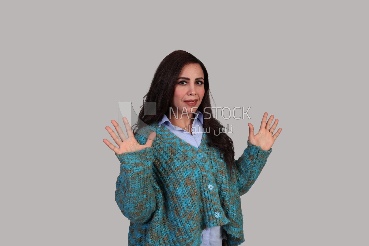 beautiful woman with long brown hair and winter clothes standing surprised