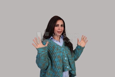 beautiful woman with long brown hair and winter clothes standing surprised