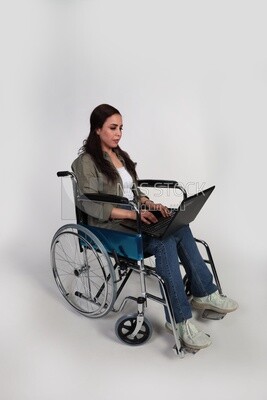 woman sitting in a wheelchair with a laptop, patient, the concept of medicine and health care, an appointment to receive treatment in the hospital, emergency.