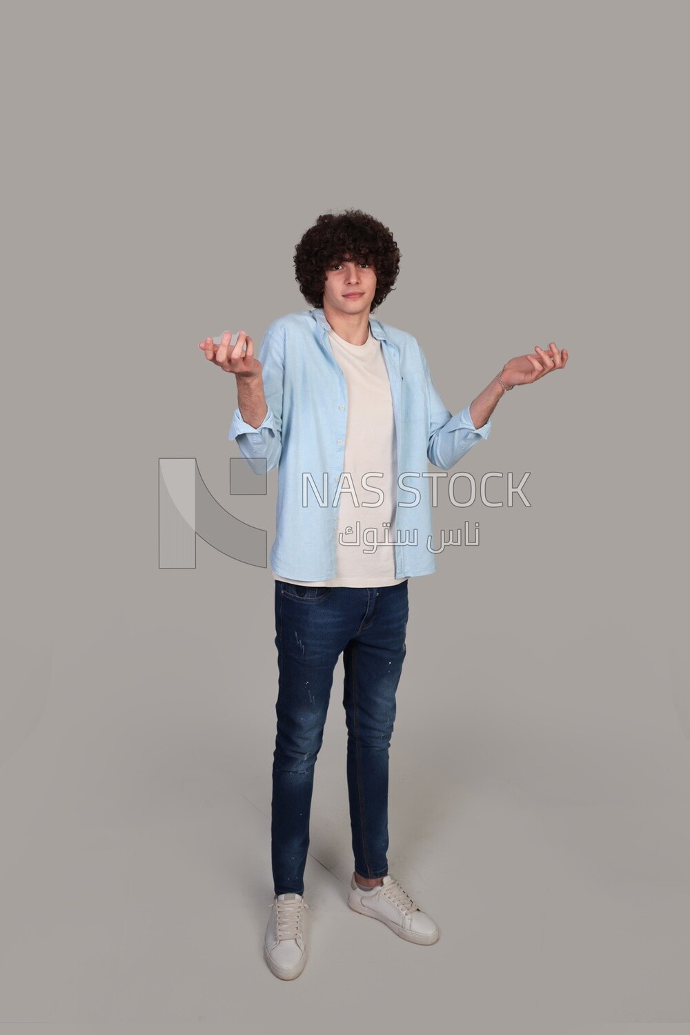 young man wearing a shirt and standing wondering