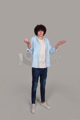young man wearing a shirt and standing wondering