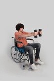 man sitting in a wheelchair holding dumbbells, patient, the concept of medicine and health care, an appointment to receive treatment in the hospital, emergency.