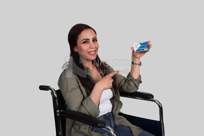 woman sitting in a wheelchair holding a credit card, patient, the concept of medicine and health care, an appointment to receive treatment in the hospital, emergency.