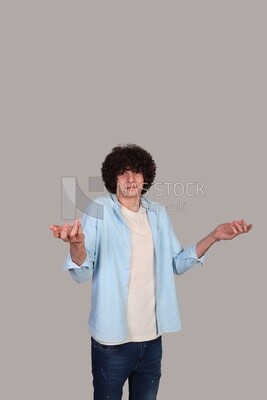 young man wearing a shirt and standing wondering