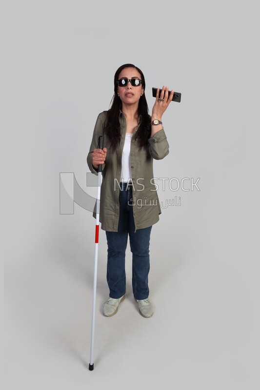 blind woman walking with a white cane holding her mobile, patient, medicine and health care concept, medical professions and jobs.