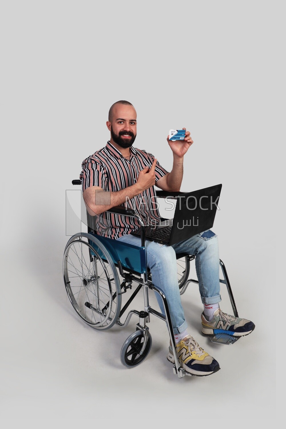 man sitting in a wheelchair with a laptop holding a credit card, patient, the concept of medicine and health care, an appointment to receive treatment in the hospital, emergency.
