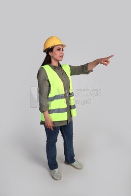 woman engineer hand gestures to express quality and distinction, a veiled construction engineer wearing a work safety suit, work helmet, wearing a mask for protection and prevention of viruses, formal