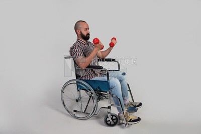 man sitting in a wheelchair holding dumbbells, patient, the concept of medicine and health care, an appointment to receive treatment in the hospital, emergency.