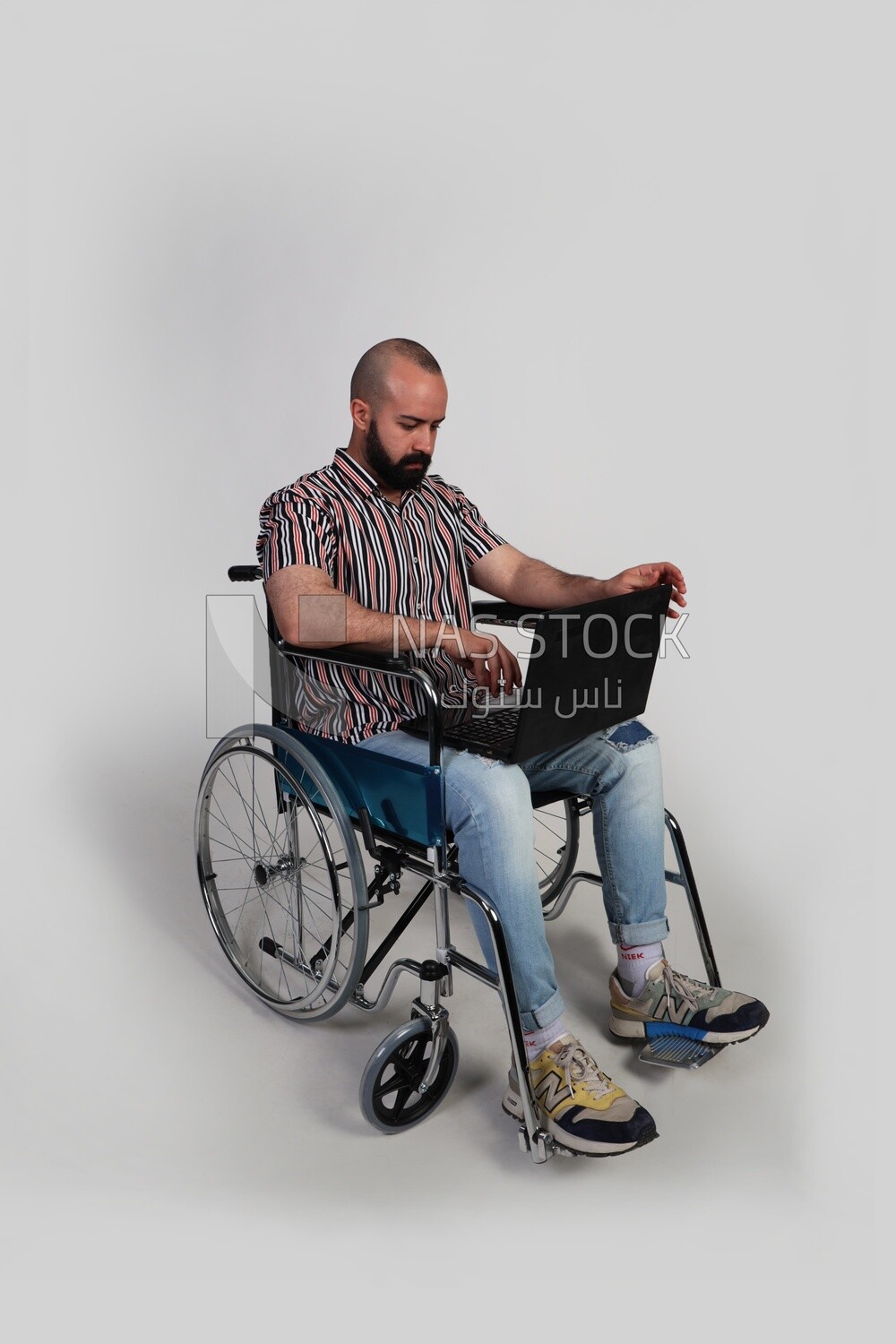 man sitting in a wheelchair with a laptop, patient, the concept of medicine and health care, an appointment to receive treatment in the hospital, emergency.