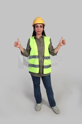 woman engineer hand gestures to express quality and distinction, a veiled construction engineer wearing a work safety suit, work helmet, wearing a mask for protection and prevention of viruses, formal