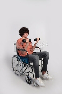 man sitting in a wheelchair holding dumbbells, patient, the concept of medicine and health care, an appointment to receive treatment in the hospital, emergency.
