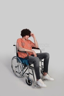 man sitting in a wheelchair holding dumbbells, patient, the concept of medicine and health care, an appointment to receive treatment in the hospital, emergency.