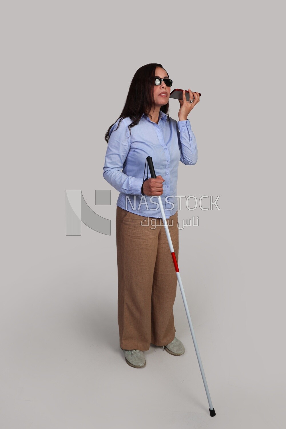 blind woman walking with a white cane holding her mobile, patient, medicine and health care concept, medical professions and jobs, disabled people