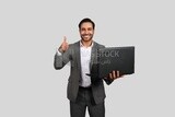 Photo of a businessman with a formal suit holding a laptop, business development and partnerships, business meeting, Model