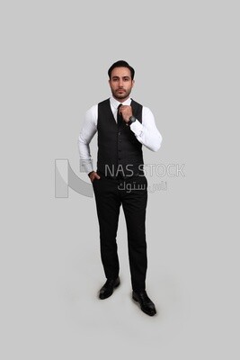 صورة لرجل أعمال يرتدي بدلة رسمية ويضع يده على ربطة العنق ، تطوير الأعمال والشراكات ، اجتماع عمل ، موديل