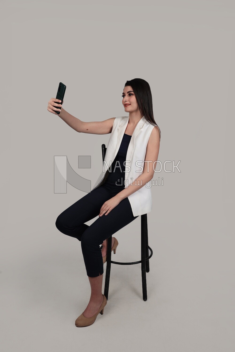 Photo of a businesswoman with formal wear sitting on a chair and taking a selfie, business development and partnerships, business meeting, Model