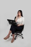 Photo of a businesswoman with formal wear sitting on a chair working on a laptop while talking on the phone, business development and partnerships, business meeting, Model