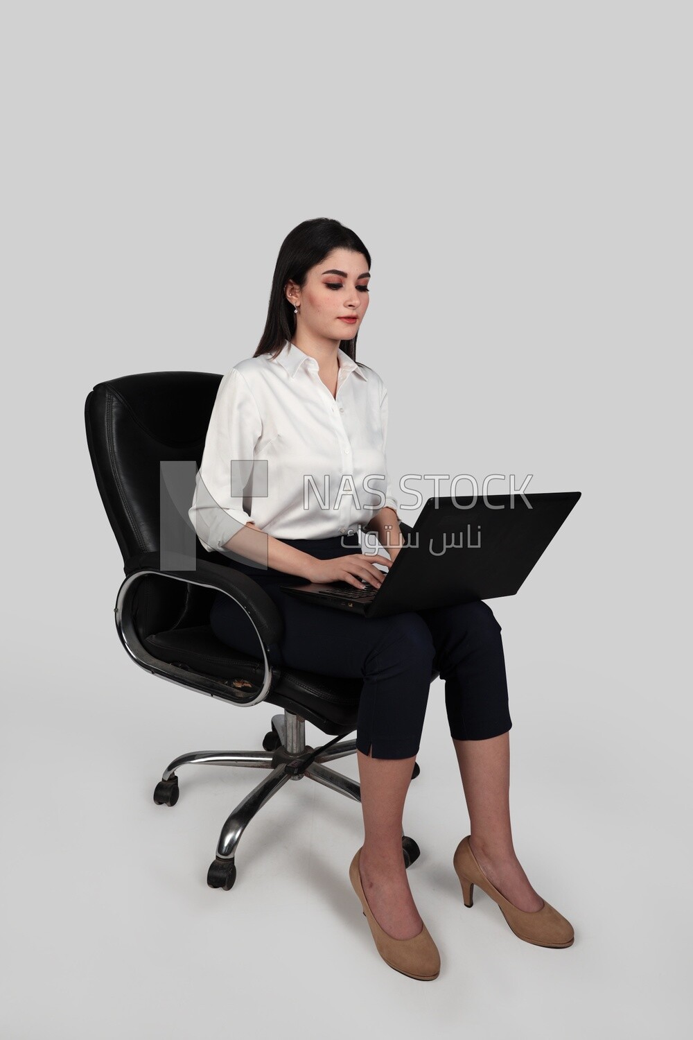 Photo of a businesswoman with formal wear sitting on a chair working on a laptop, business development and partnerships, business meeting, Model