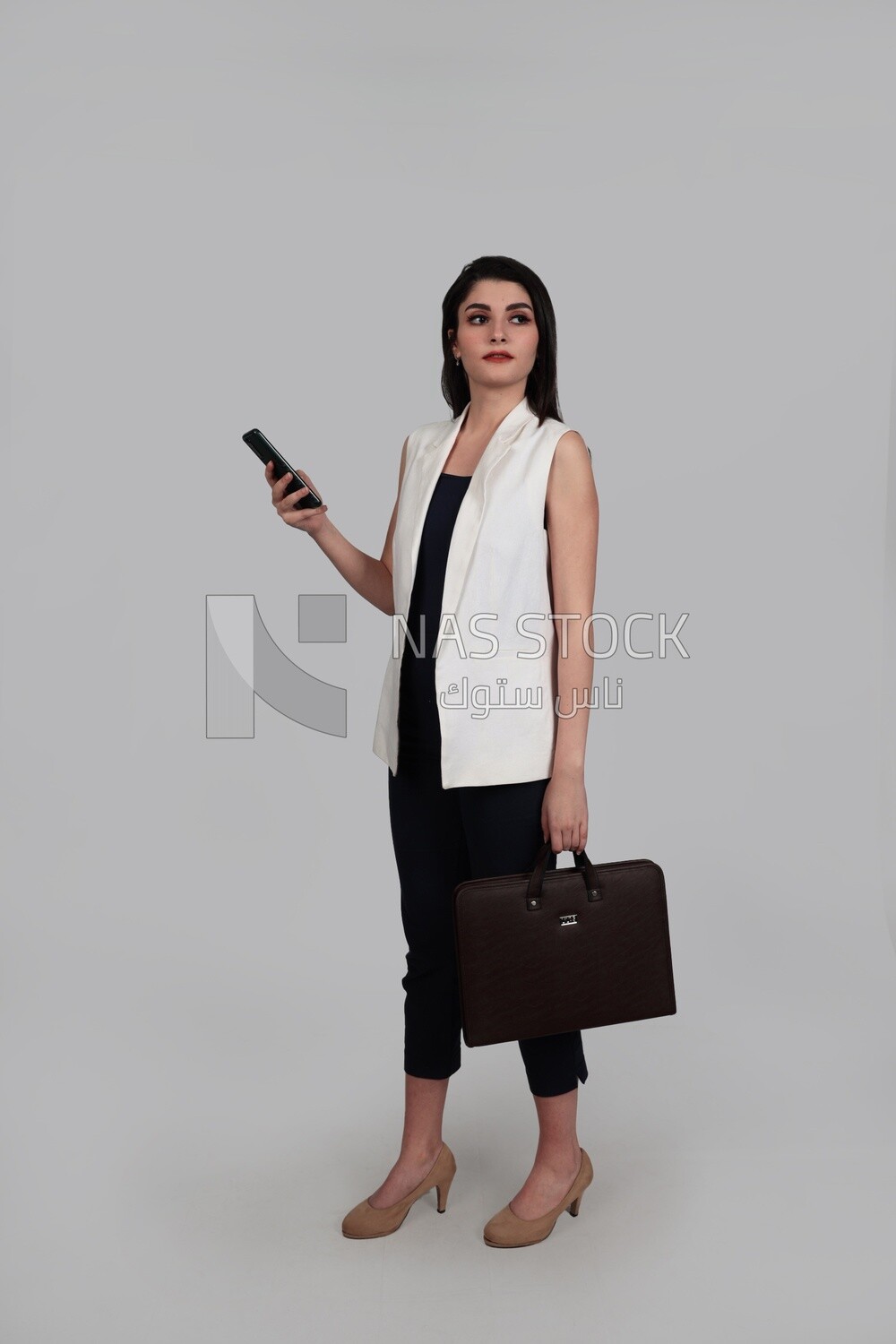 Photo of a businesswoman with formal wear holding a leather bag while checking the phone, business development and partnerships, business meeting, Model