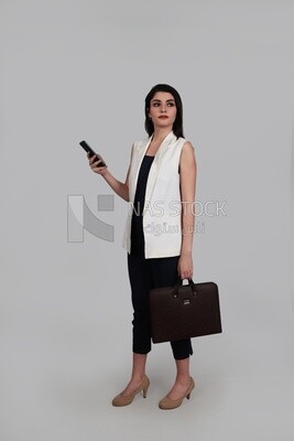 Photo of a businesswoman with formal wear holding a leather bag while checking the phone, business development and partnerships, business meeting, Model