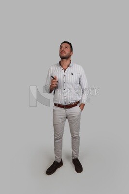 Photo Of a Handsome man standing looks thinking, Smiling Man, Wearing Casual Clothes Posing In a Light Room Interior, Smiling At the Camera, looking away