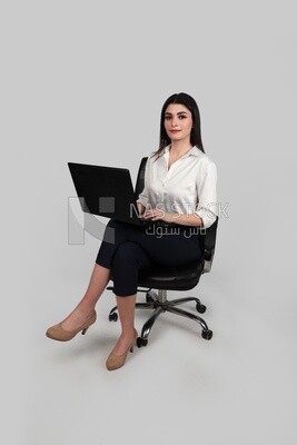 Photo of a businesswoman with formal wear sitting on a chair working on a laptop, business development and partnerships, business meeting, Model