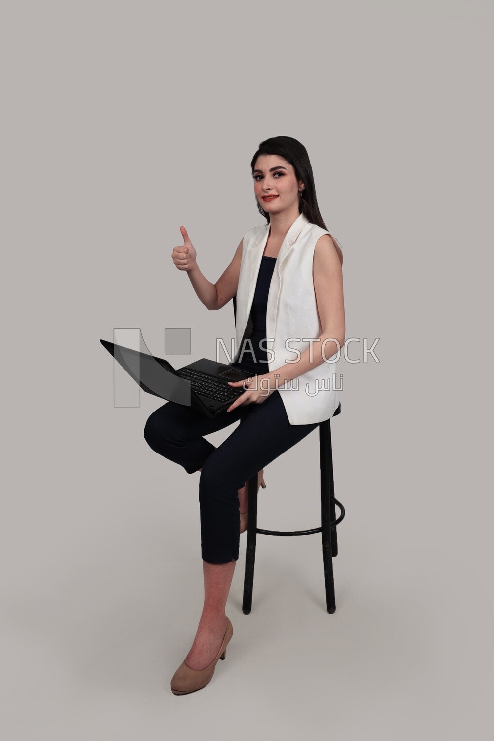 Photo of a businesswoman with formal wear sitting on a chair working on a laptop, business development and partnerships, business meeting, Model