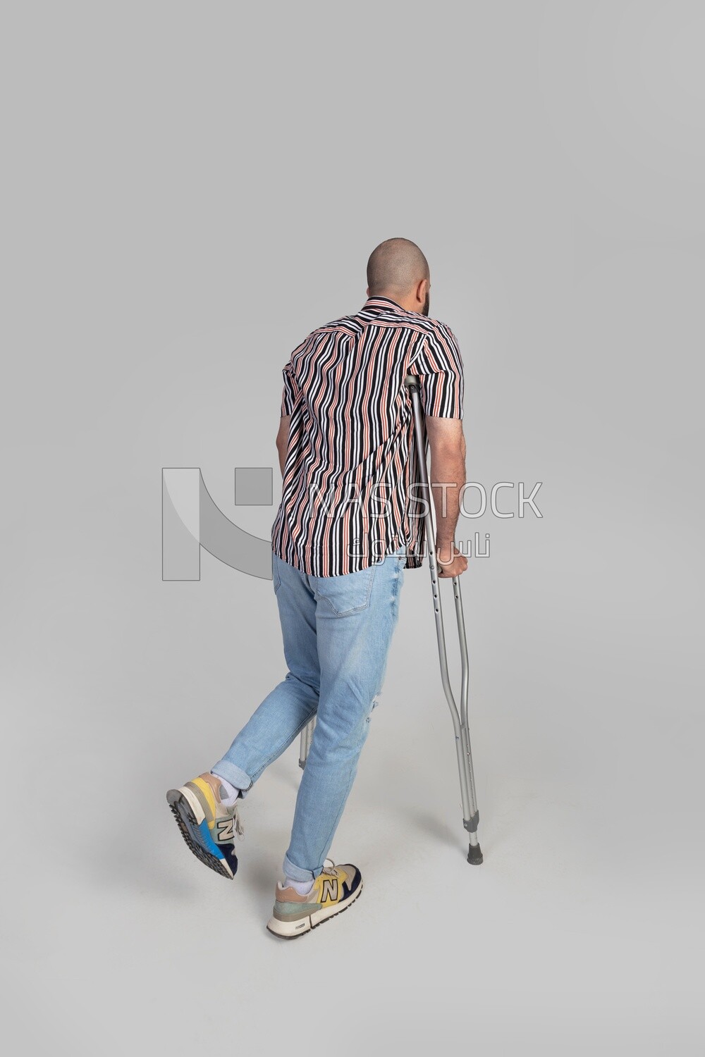 back view of a man with an injured leg walking with crutches, patient, medicine and health care concept, medical professions and jobs.