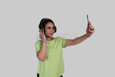 girl wearing headphones and taking a selfie