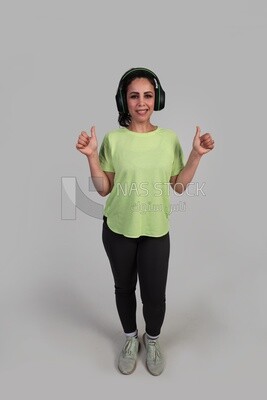 girl wearing earphones and giving her thumbs up