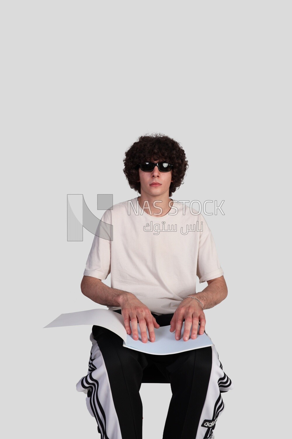 blind young man reading a book in Braille