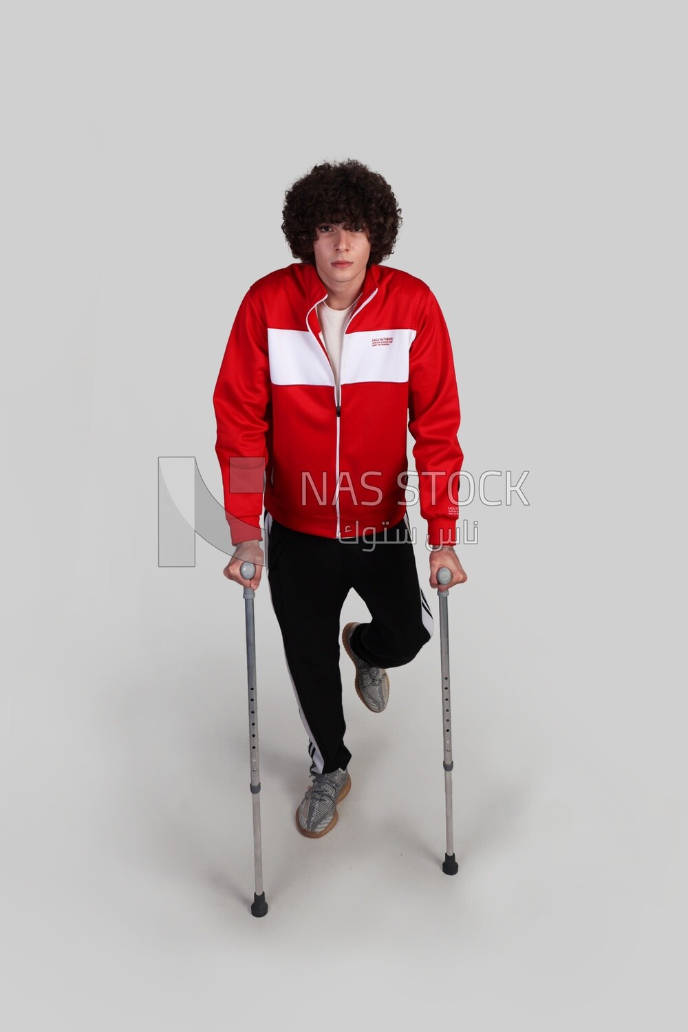 young man with a problem in his foot walking with crutches
