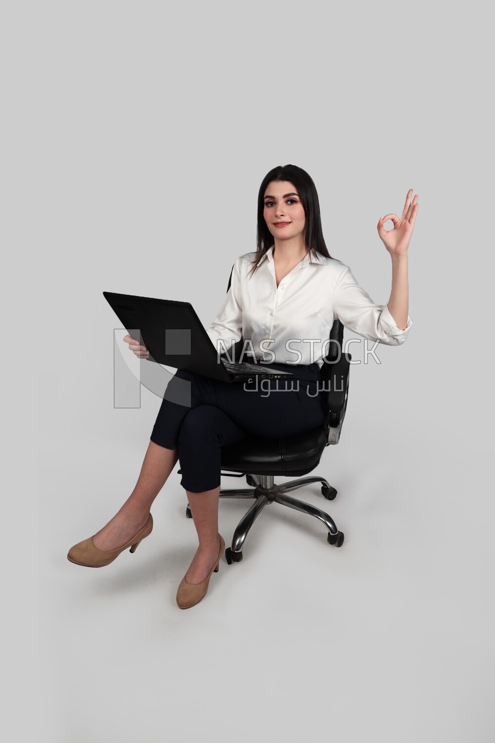Photo of a businesswoman with formal wear sitting on a chair working on a laptop, business development and partnerships, business meeting, Model