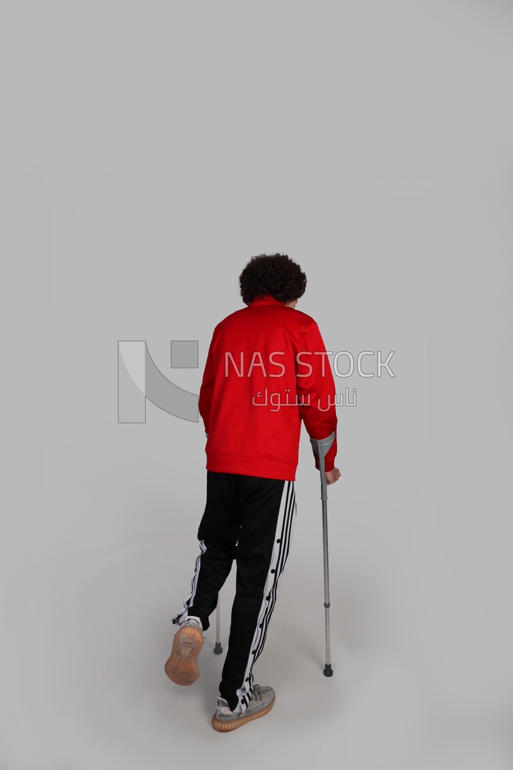 young man with a foot injury walking with crutches