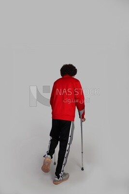 young man with a foot injury walking with crutches